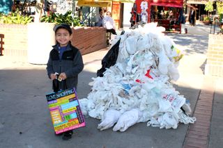 Boy poses with his reusable bag next to deflated Bag Monster